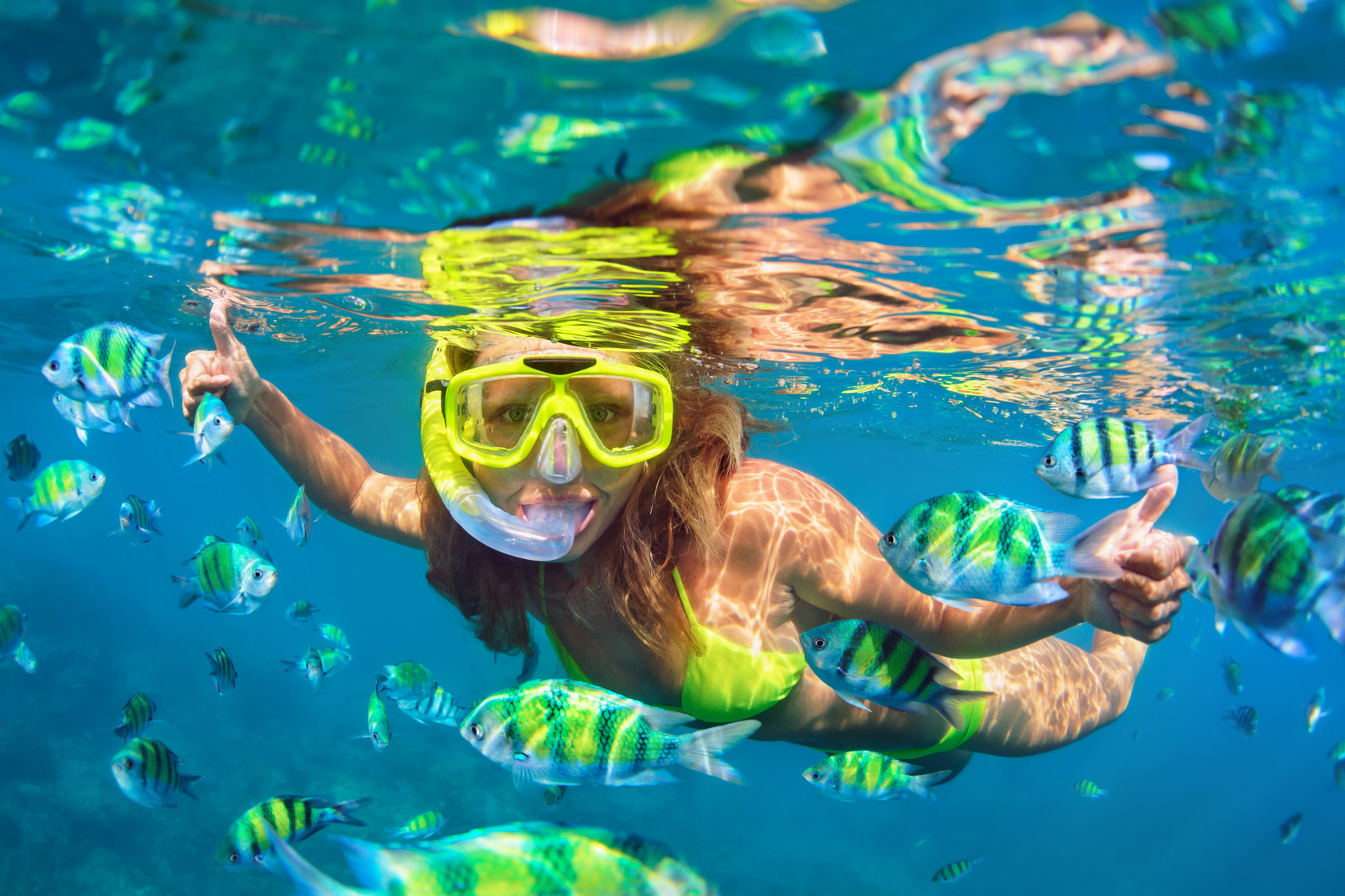 Happy family - girl in snorkeling mask dive underwater with fishes school in coral reef sea pool. Travel lifestyle, water sport outdoor adventure, swimming lessons on summer beach holidays with child.